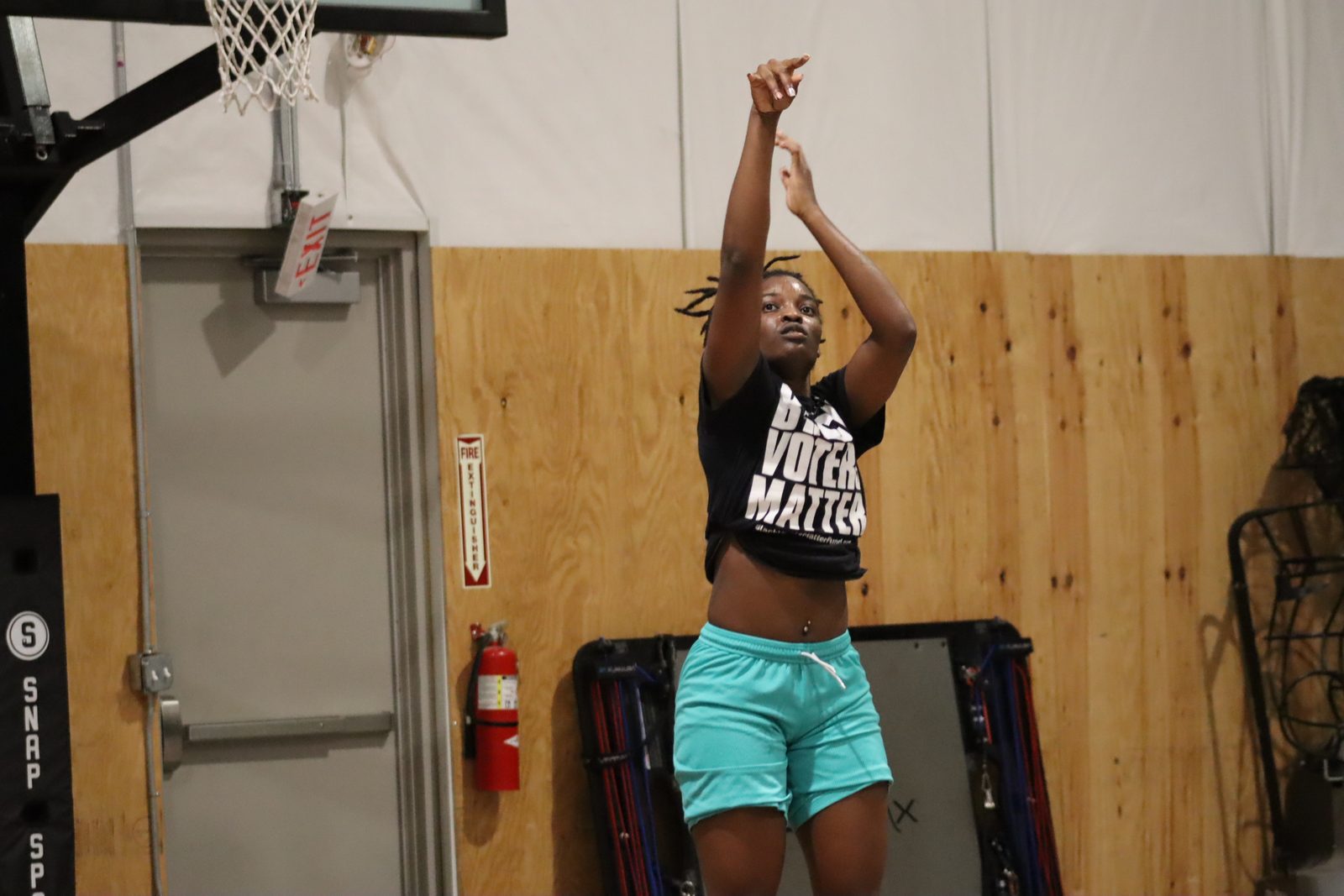 An athlete rising into a jump shot in the academy gym