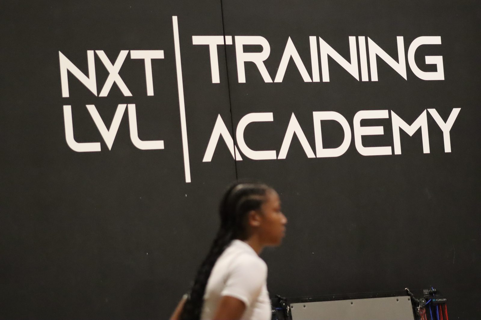An athlete on the floor under the NXT LVL Training Academy wall