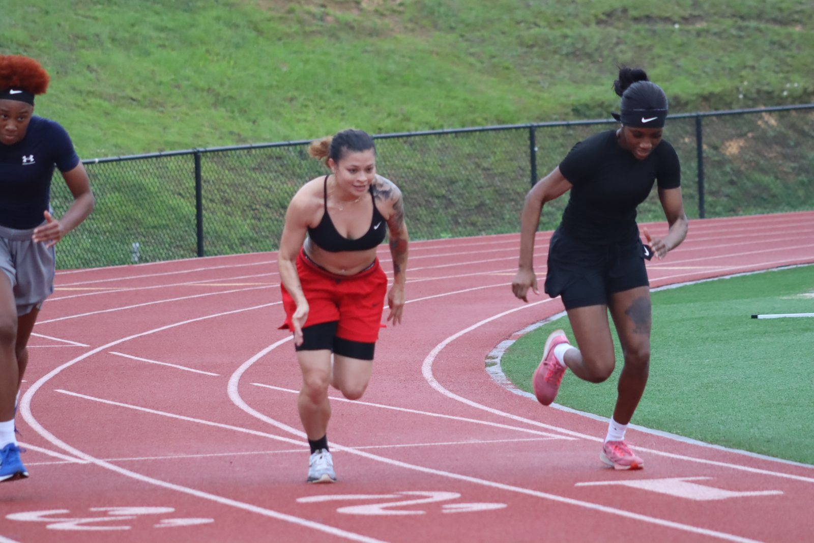 Athletes sprinting on the track in a Next Level session